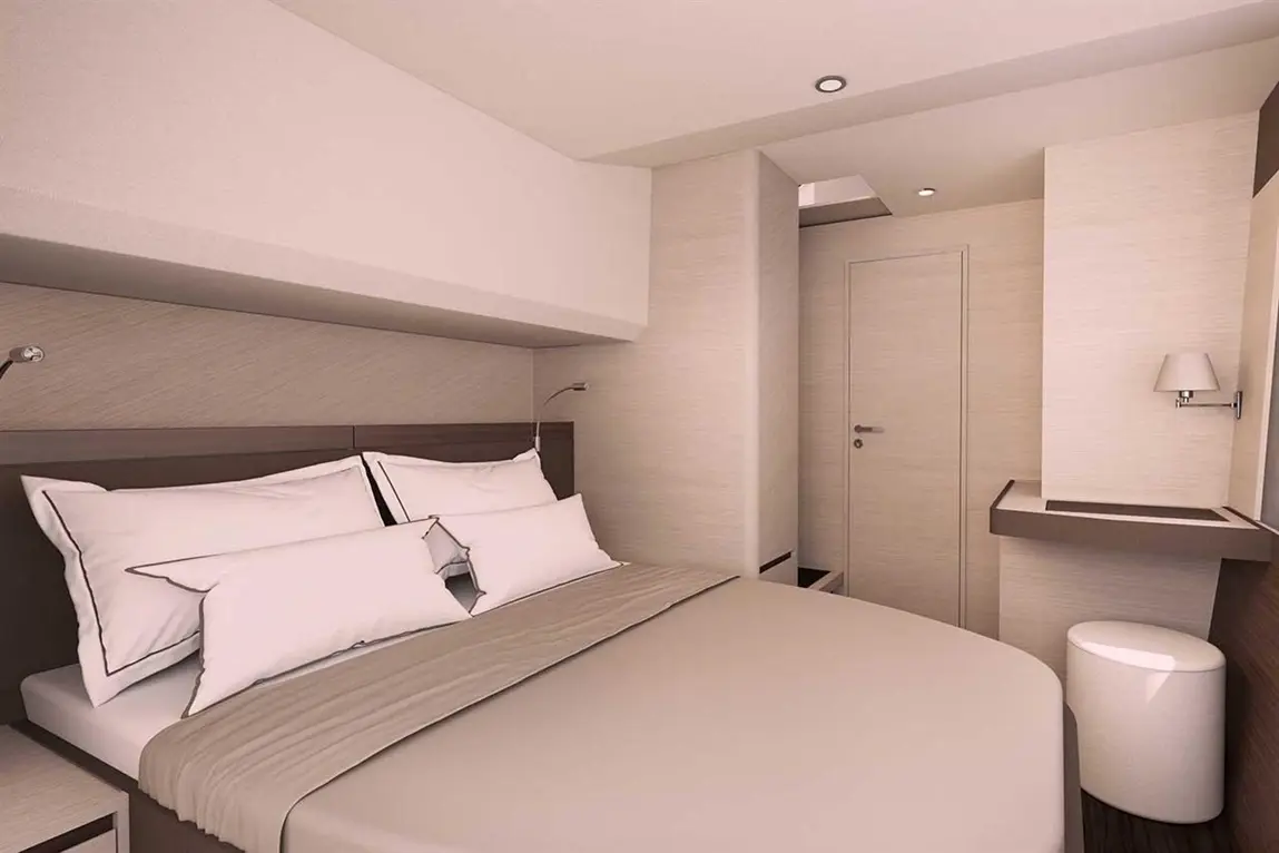 Modern hotel bedroom featuring a double bed with decorative pillows, a bedside lamp, and a minimalist desk.